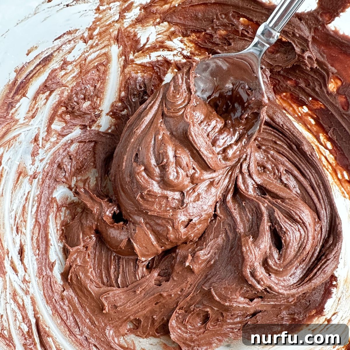 Velvety Brownie Frosting 5 Bowl of chocolate frosting and spoon.