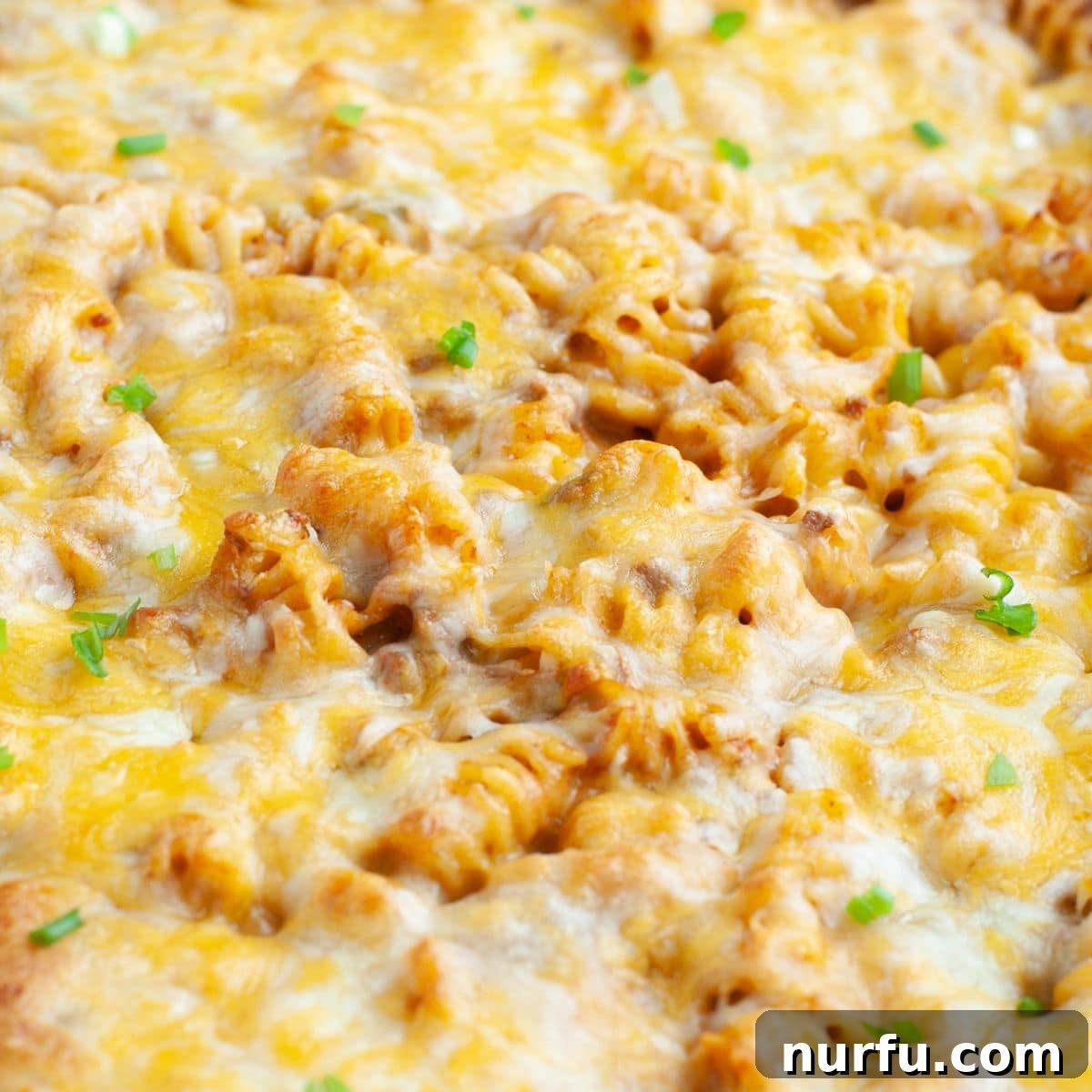 A closer look at the finished rotini casserole with a generous layer of melted cheese, showcasing its inviting texture.