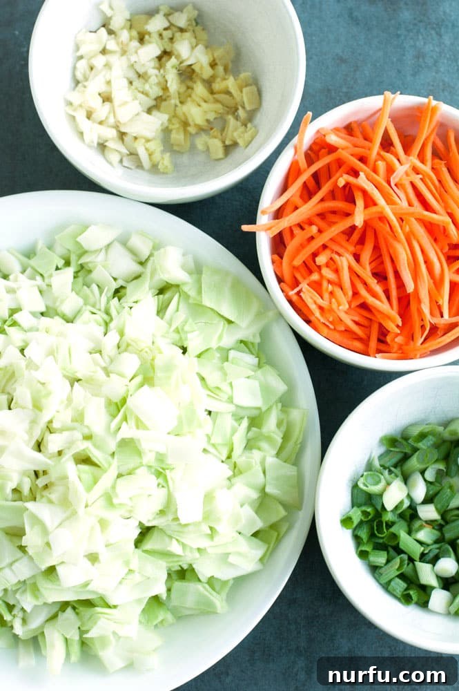 Inside-Out Pork Egg Roll Bowl 4 A wide shot of all the fresh ingredients, including diced pork, cabbage, carrots, and aromatics, laid out and ready for cooking a Pork Egg Roll in a Bowl.