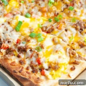 Hand holding a piece of breakfast pizza.