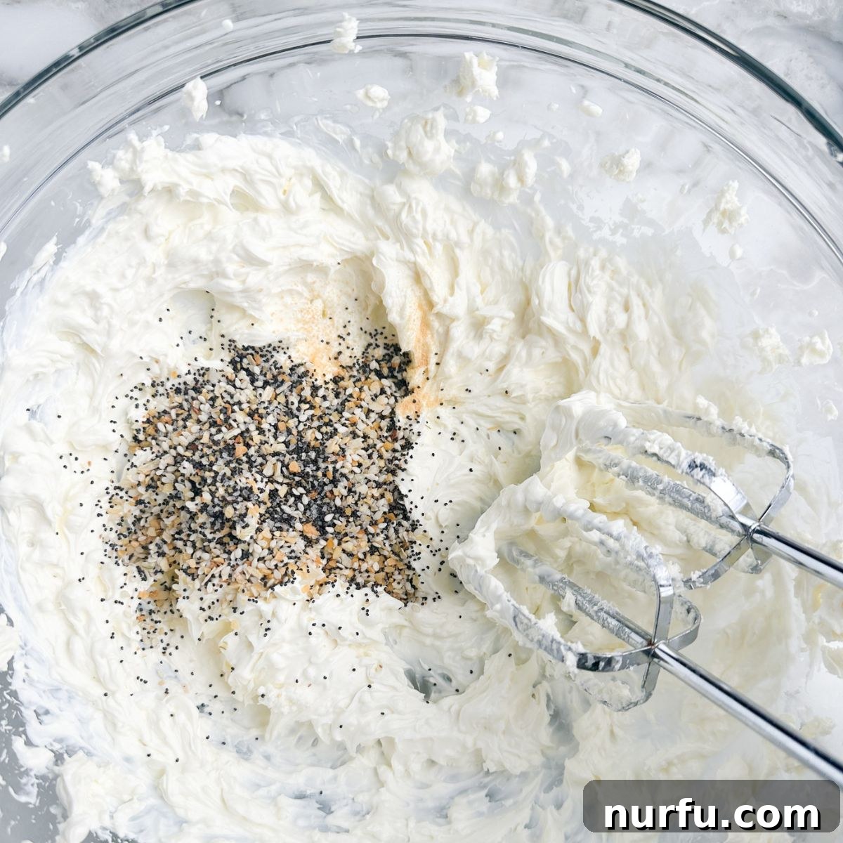 Quick & Creamy Bagel Dip 5 Whipped cream cheese mixture in a bowl with everything bagel seasoning added, ready for the final mix.