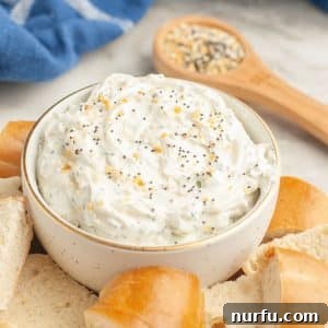 Bowl of everything bagel dip with cut up bagels, ready for serving.