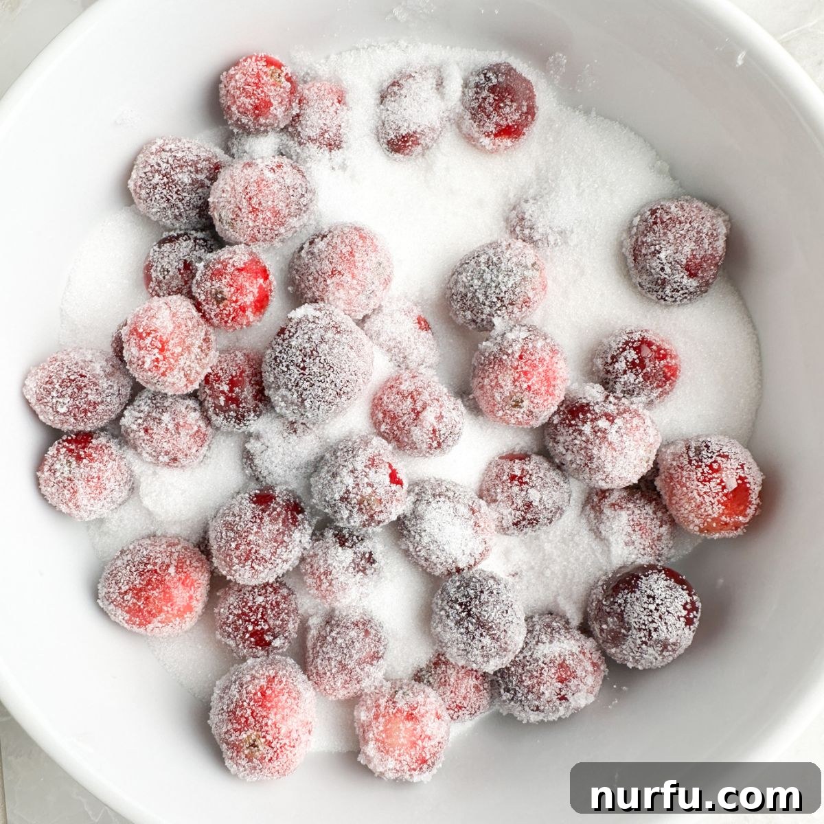 Sweet Sparkle Cranberries 6 Bowl with sugar and cranberries being tossed for the final coating.