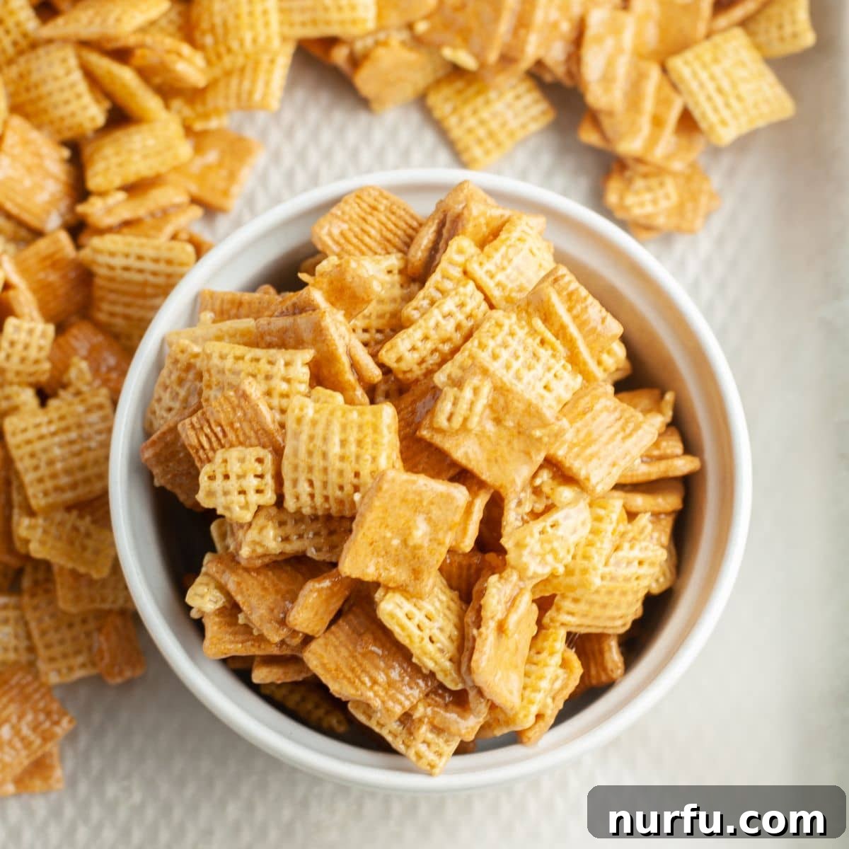 A beautifully presented bowl of Sweet Chex Mix, ready to be enjoyed, showcasing its irresistible glaze and varied cereal components.
