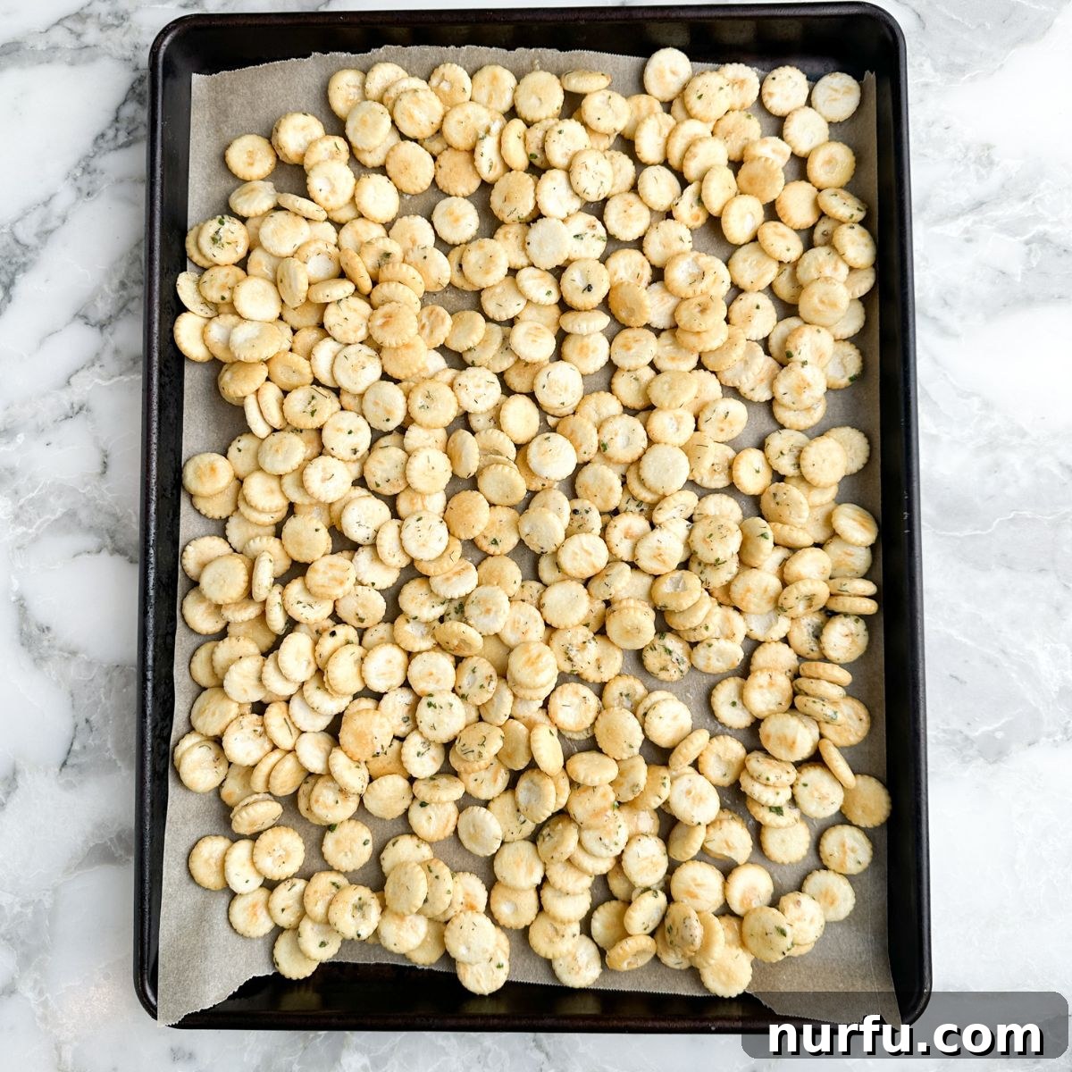Homemade Savory Oyster Crackers in Minutes 6 Baking sheet with seasoned oyster crackers spread out in a single layer.