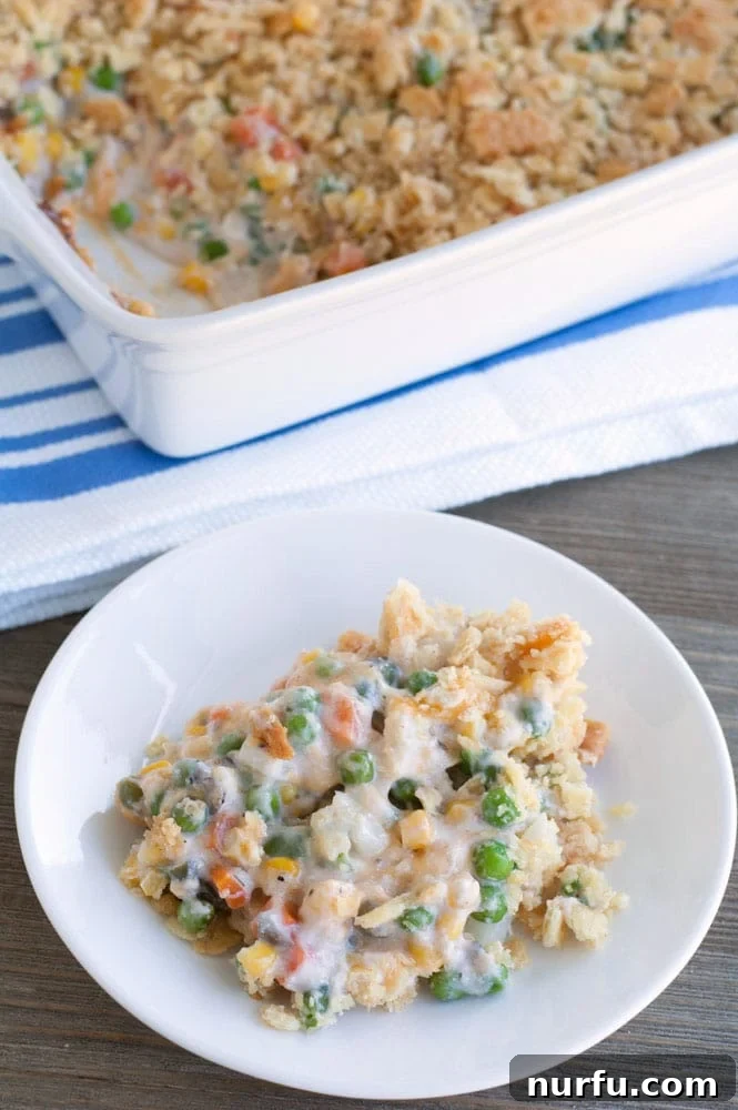 Effortless Cheesy Vegetable Casserole 2 A serving of Cheesy Vegetable Casserole with visible peas and carrots.