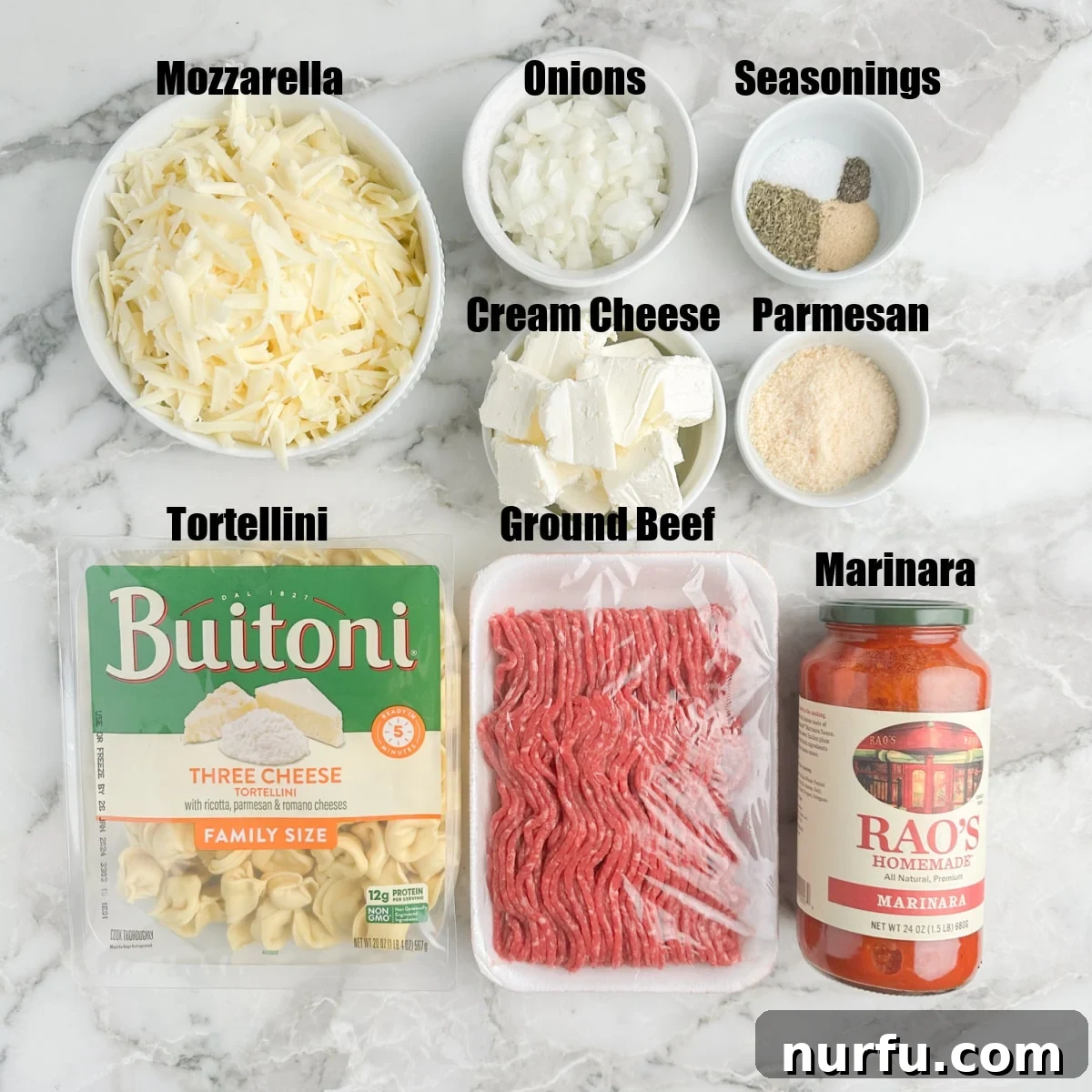 Golden Baked Tortellini 3 A collection of fresh ingredients laid out: pasta tortellini, raw ground beef, a bowl of shredded cheeses, a jar of marinara sauce, and various spices.
