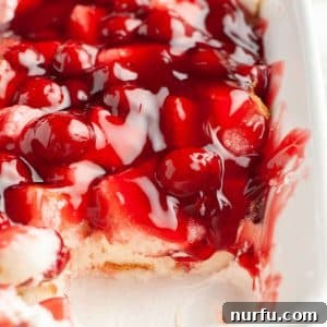 A delightful baking dish filled with a creamy cherry dessert, ready to be served.