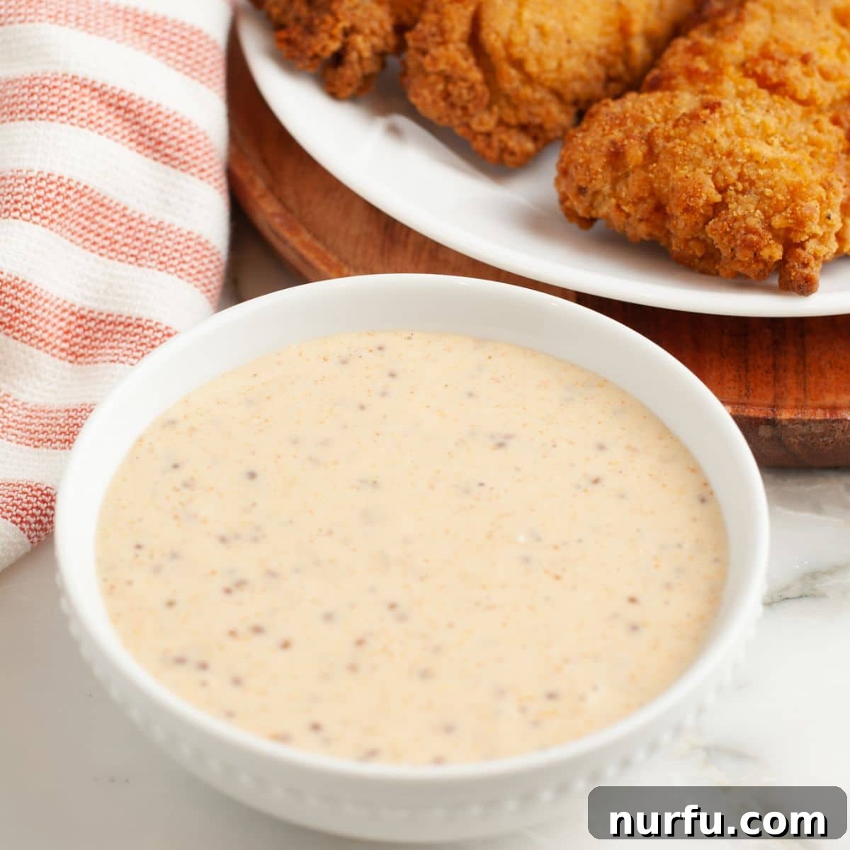 Mardi Gras Zest Mustard Dip 5 Bowl of creamy sauce with chicken tenders.