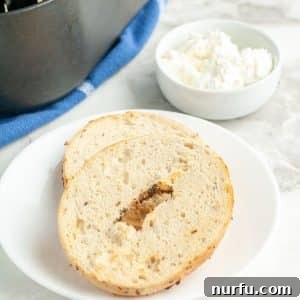 Toasted bagel on a plate with a bowl of cream cheese.