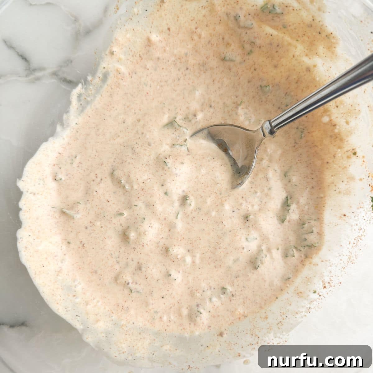 Zesty Homemade Remoulade Sauce 5 Bowl with mayonnaise based sauce and a spoon.