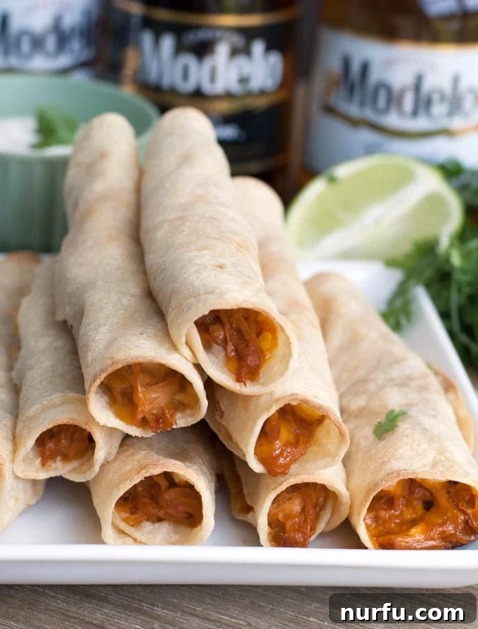 Game Day BBQ Taquitos with Fresh Garnish Crispy BBQ taquitos elegantly stacked on a clean white plate, accented with a vibrant lime wedge and a sprinkle of fresh green herbs.