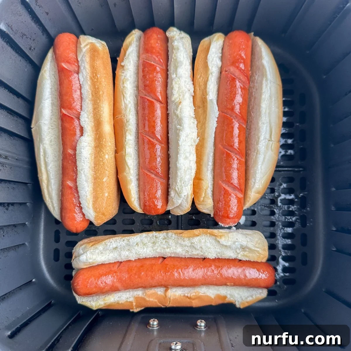 Perfect Air Fryer Hot Dogs 6 Hot dogs in buns in the air fryer.