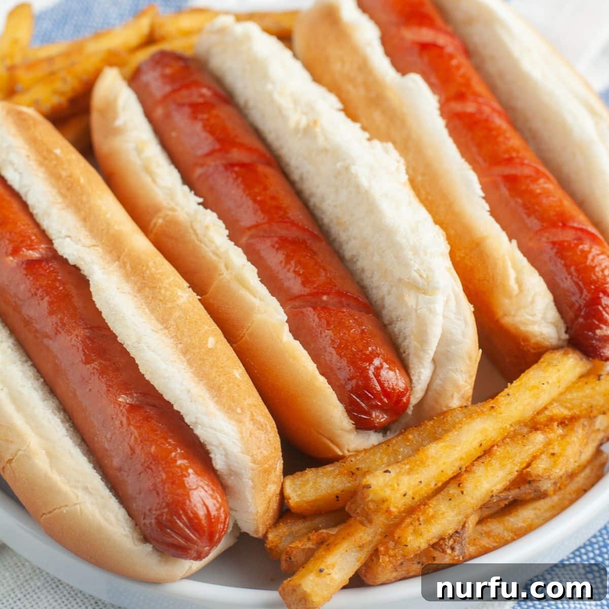 Perfect Air Fryer Hot Dogs 7 Hot dogs on a plate with french fries.