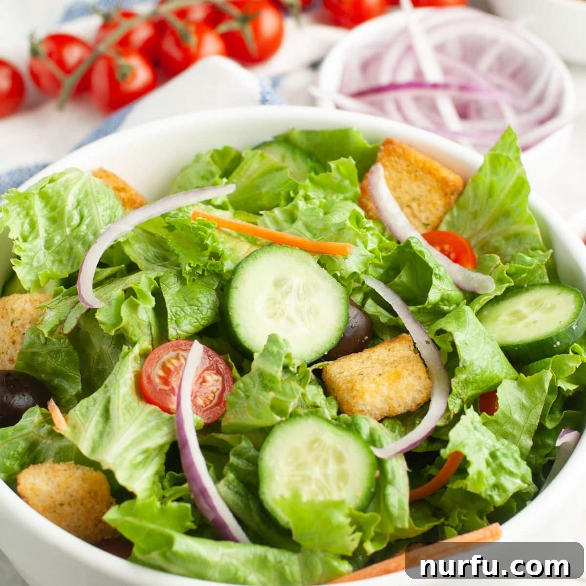 Beyond the Bun: 31 Sides for Sloppy Joes 11 Bowl of lettuce, cucumbers, tomatoes, and onions.