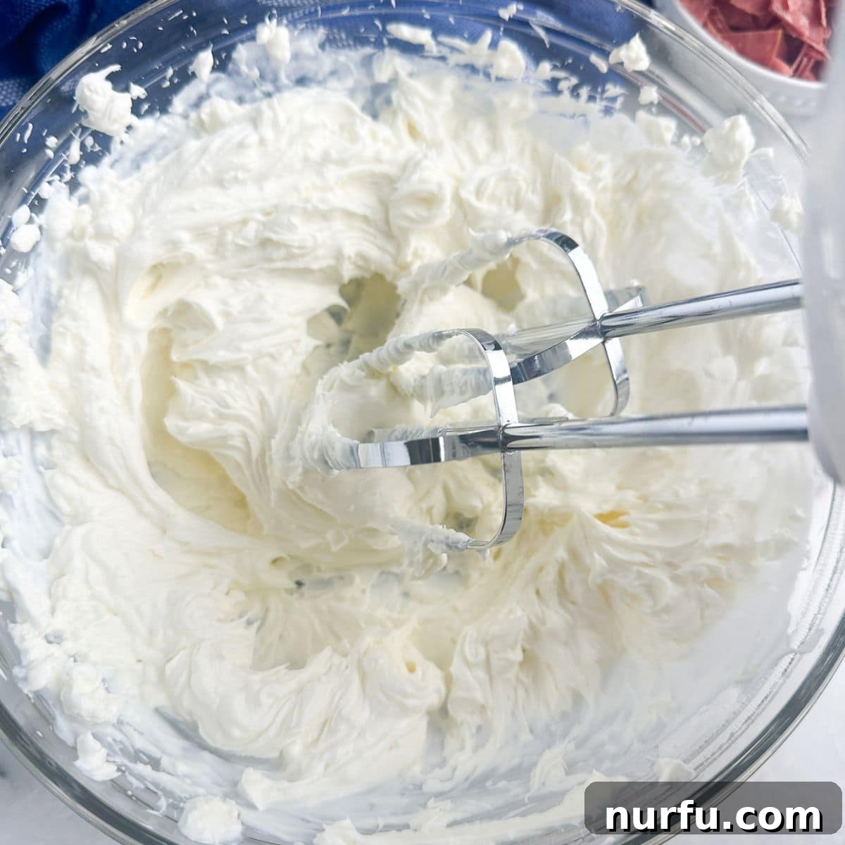 Zesty Dill Pickle & Dried Beef Dip 4 A bowl containing softened cream cheese and sour cream, ready to be blended with an electric mixer.