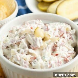 Bowl of creamy dip with dill pickles.