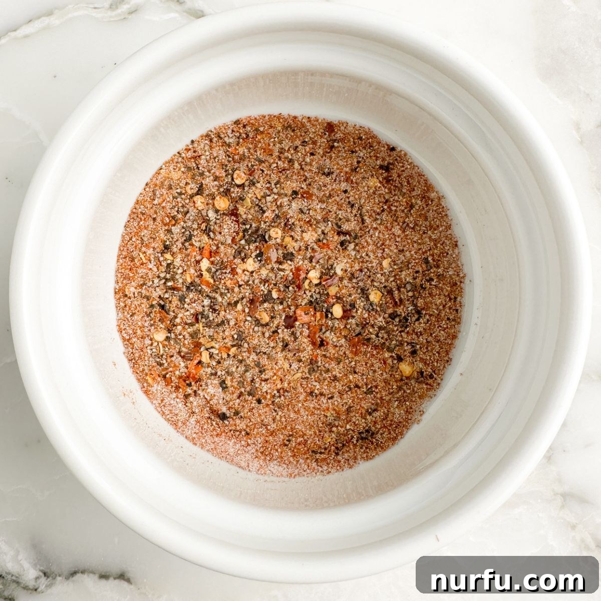 Seasoning Secrets for Ground Beef 4 A small bowl containing the freshly mixed homemade ground beef seasoning, a vibrant blend of aromatic spices, ready to be added to the meat.