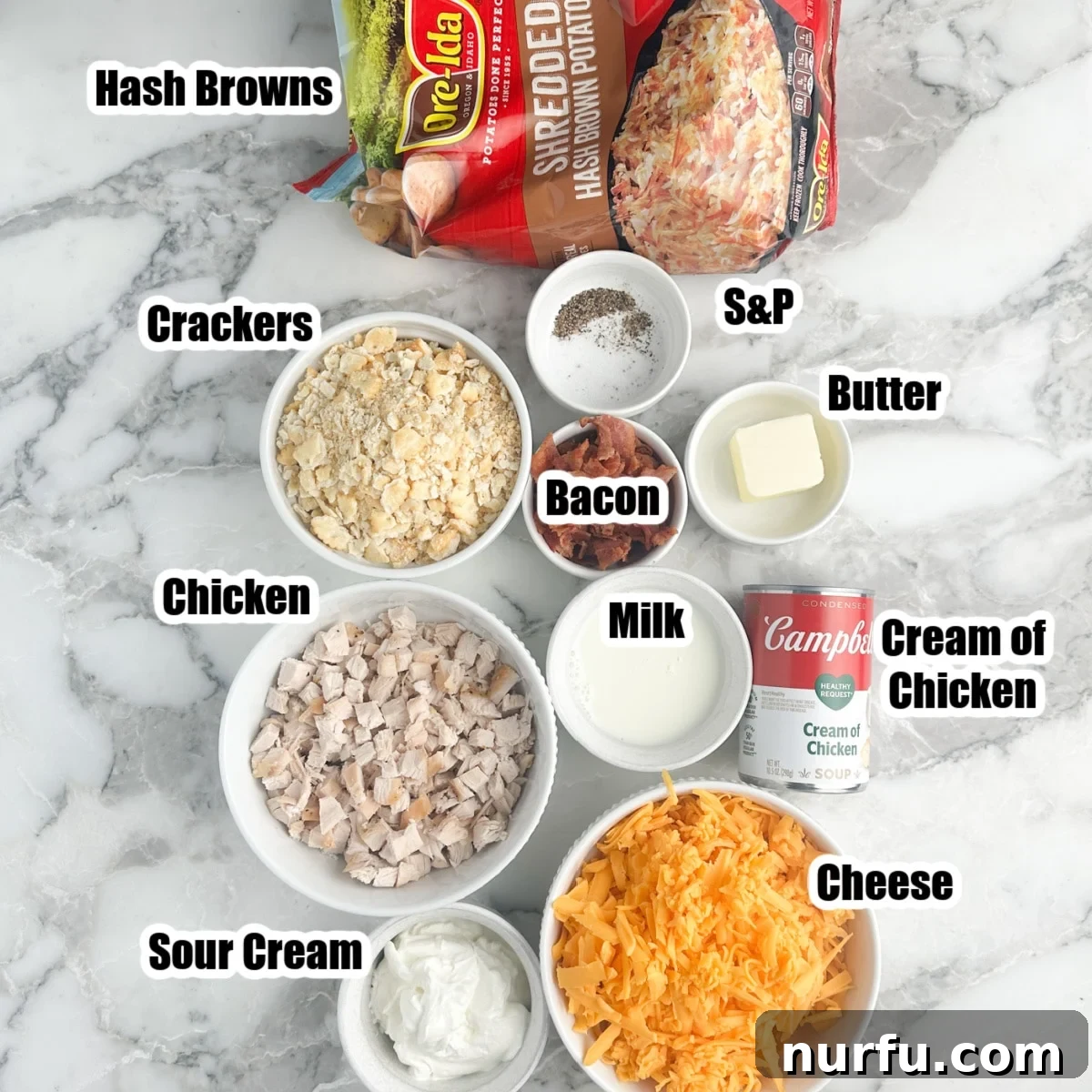 Chicken and Hash Brown Bake 3 Various ingredients laid out for hash brown chicken casserole preparation, including a bag of hash browns, a bowl of shredded cheese, diced chicken, crushed crackers, and a can of cream of chicken soup.