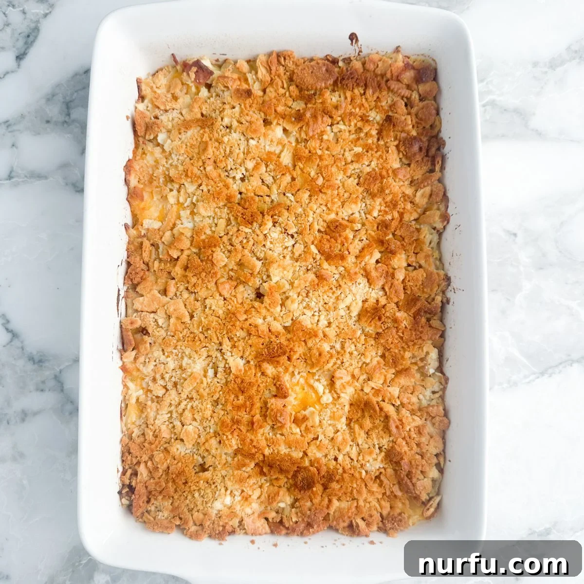 Chicken and Hash Brown Bake 6 A freshly baked hash brown chicken casserole in a dish, topped with a golden brown, crispy cracker crust.