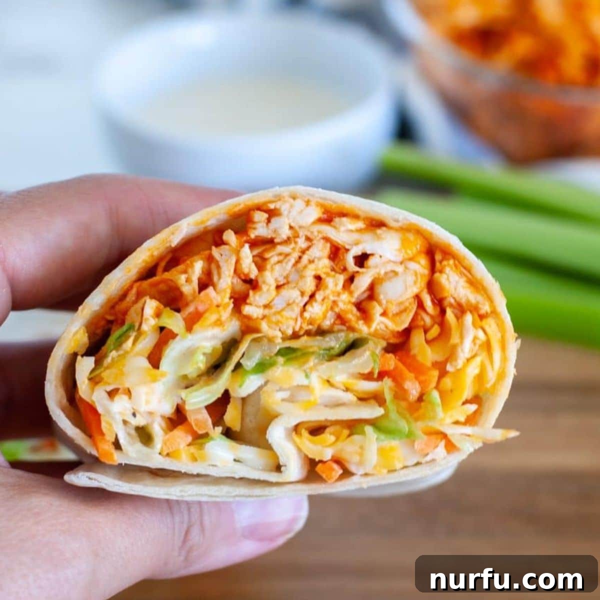 31 Effortless Friday Feasts for a Relaxing Night In 14 Hand holding buffalo chicken wrap.