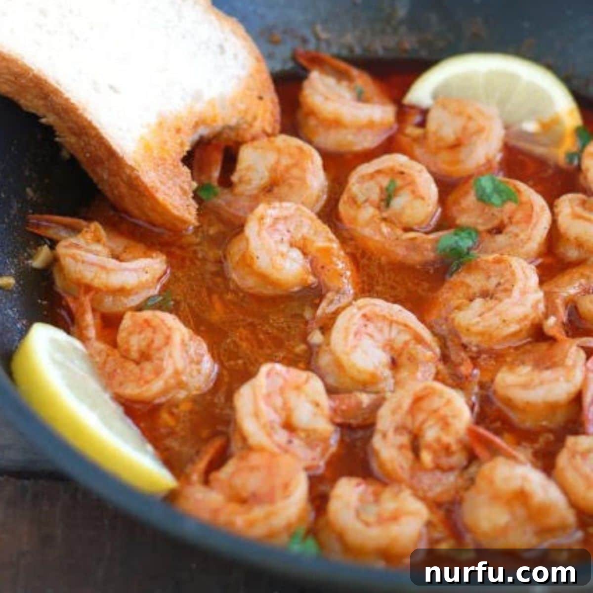 31 Effortless Friday Feasts for a Relaxing Night In 24 Pan with bbq shrimp, sliced lemon, and piece of bread.