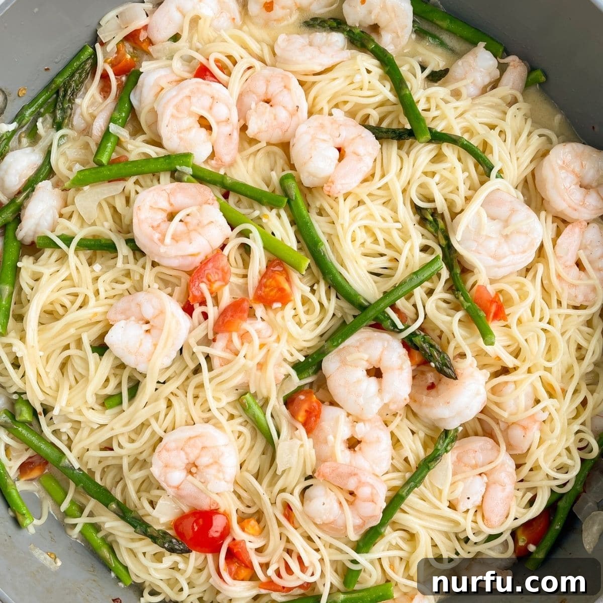 31 Effortless Friday Feasts for a Relaxing Night In 7 Skillet with pasta, shrimp, asparagus, and diced tomatoes.