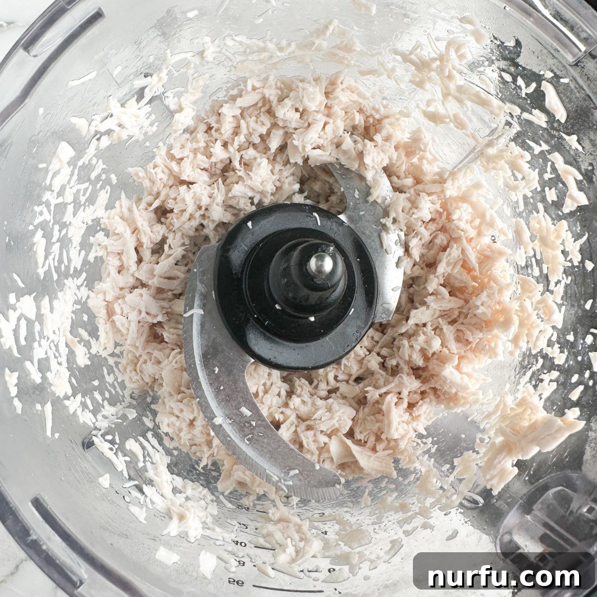 Homemade Sassy Scotty Chicken Salad 5 Finely shredded chicken in a food processor, showcasing the perfect texture for Sassy Scotty chicken salad.