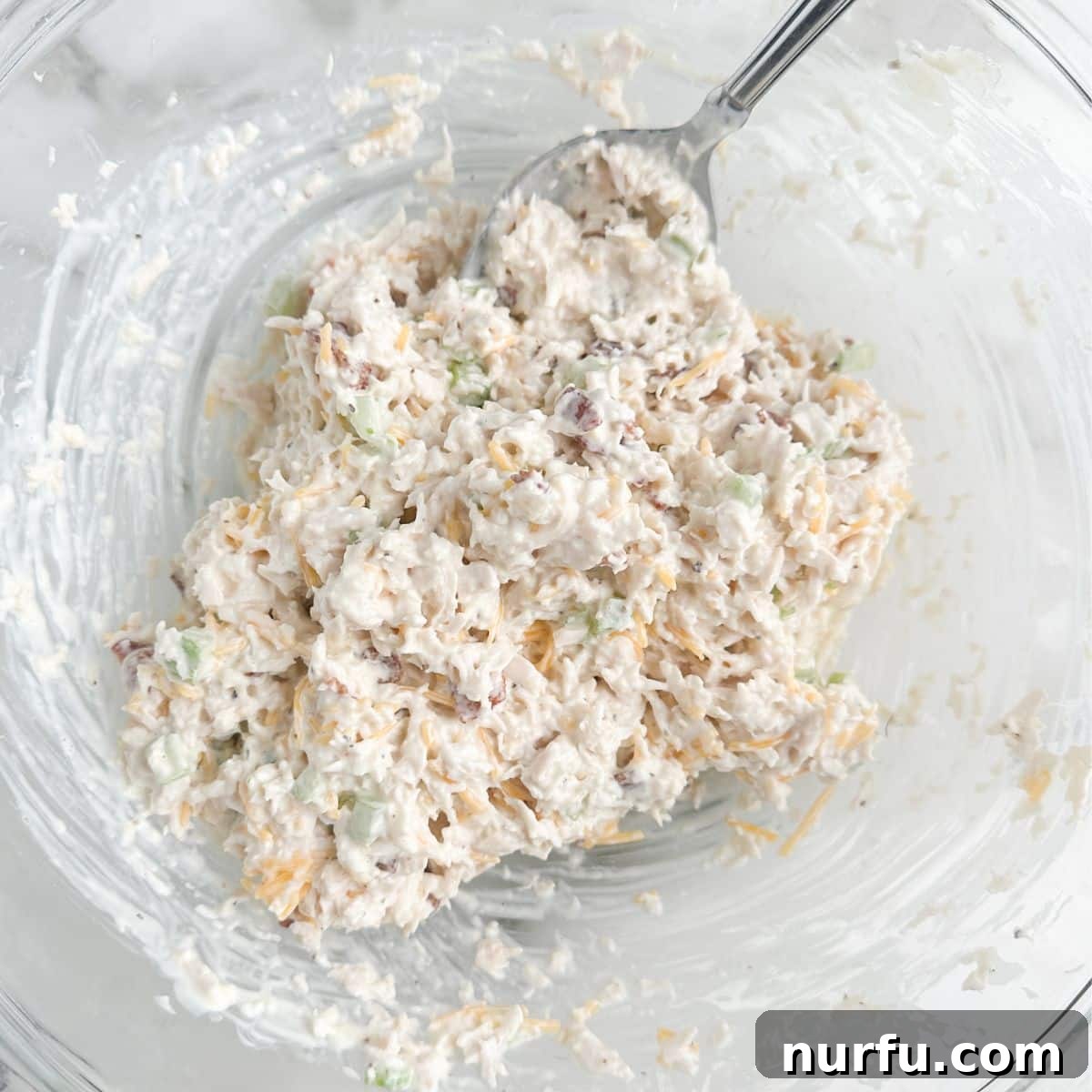 Homemade Sassy Scotty Chicken Salad 7 A bowl overflowing with the finished Sassy Scotty chicken salad, accompanied by a serving spoon, inviting you to dig in.