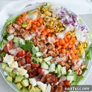 Salad with eggs, bacon, chicken and corn.