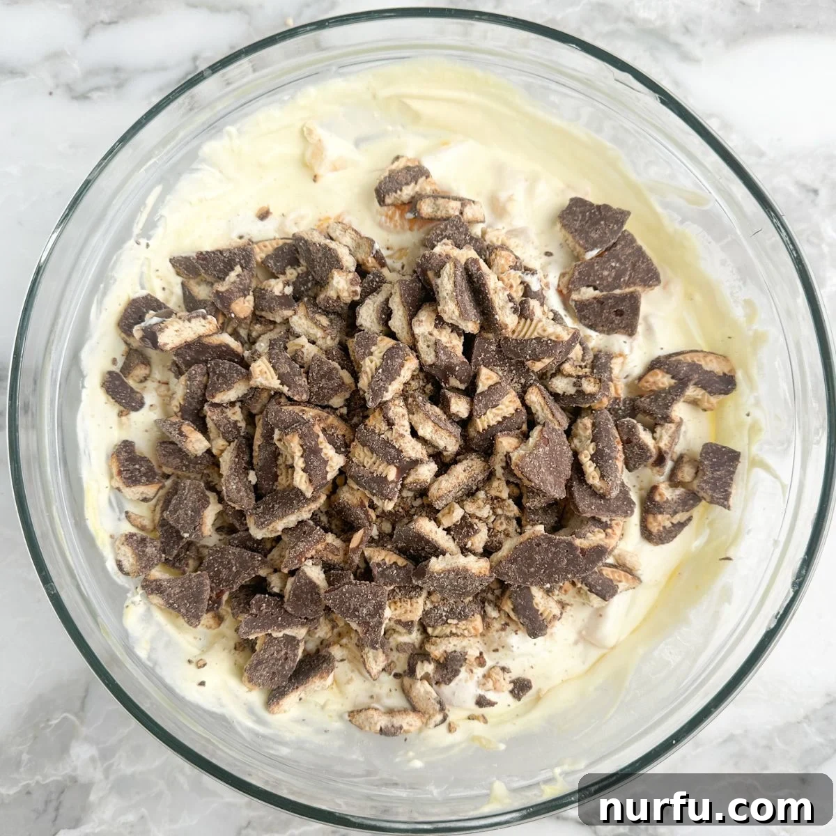 The Ultimate Cookie Salad 6 Bowl of vanilla pudding with crushed cookies being folded in.