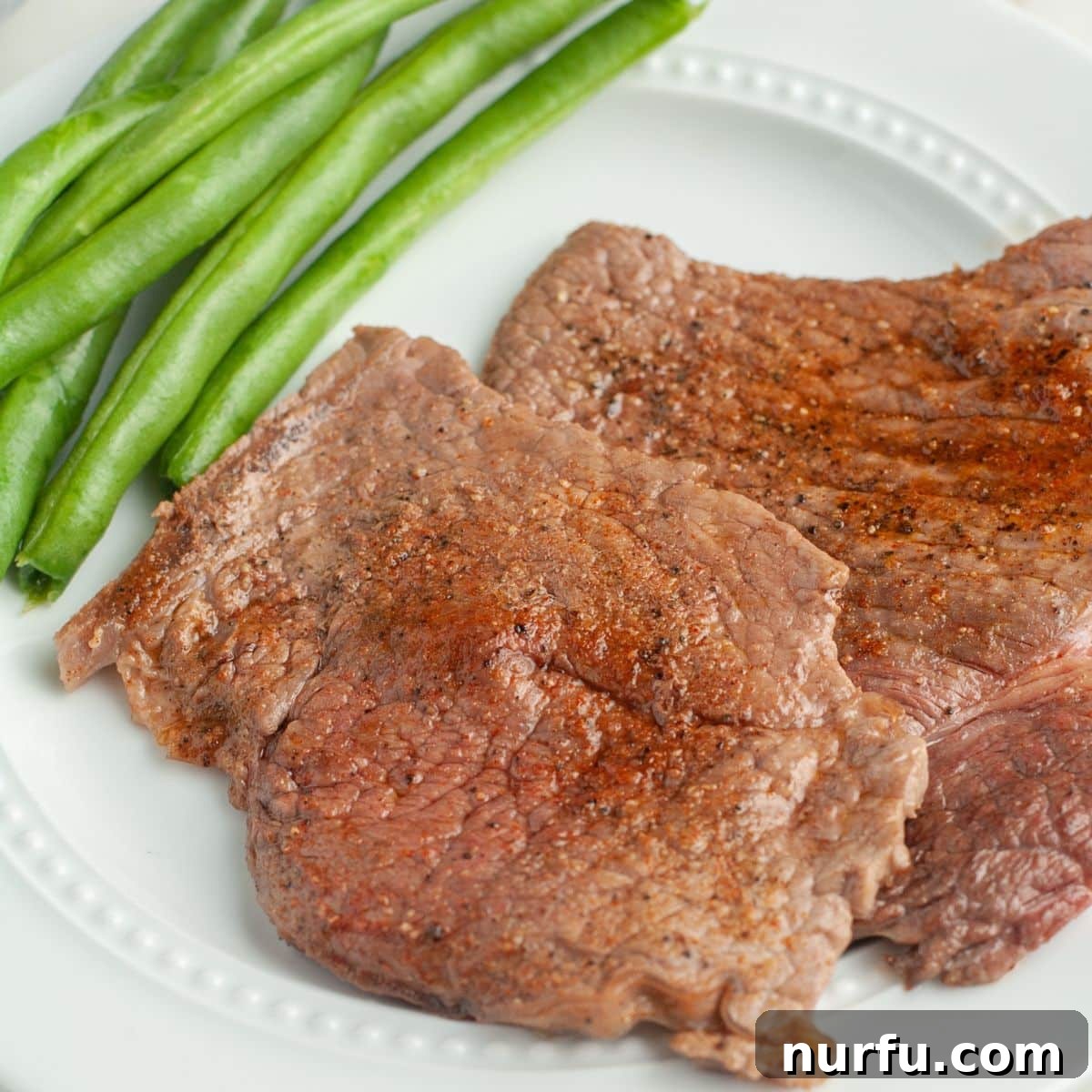31 Perfect Side Dishes for Potato Salad 16 Cooked steak on a plate with green beans.