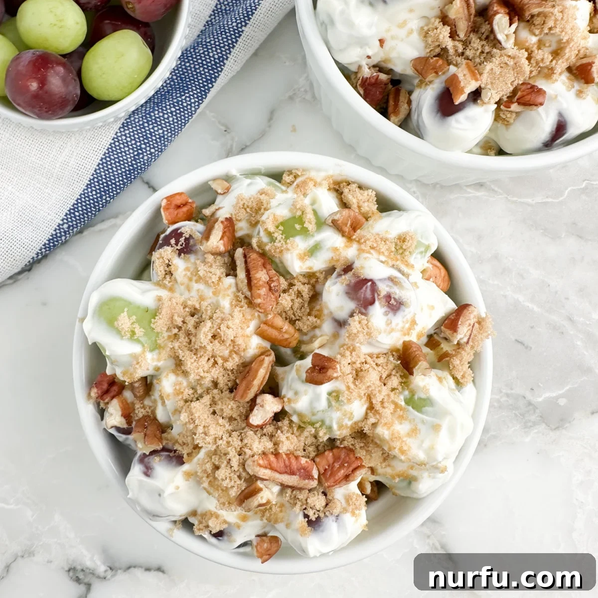 31 Perfect Side Dishes for Potato Salad 22 Bowl of green and red grape salad topped with brown sugar.