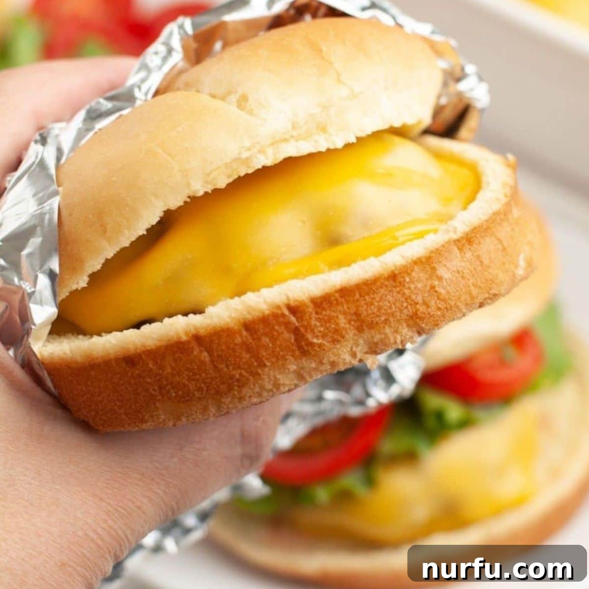 31 Perfect Side Dishes for Potato Salad 10 Hand holding cheeseburger wrapped in foil.