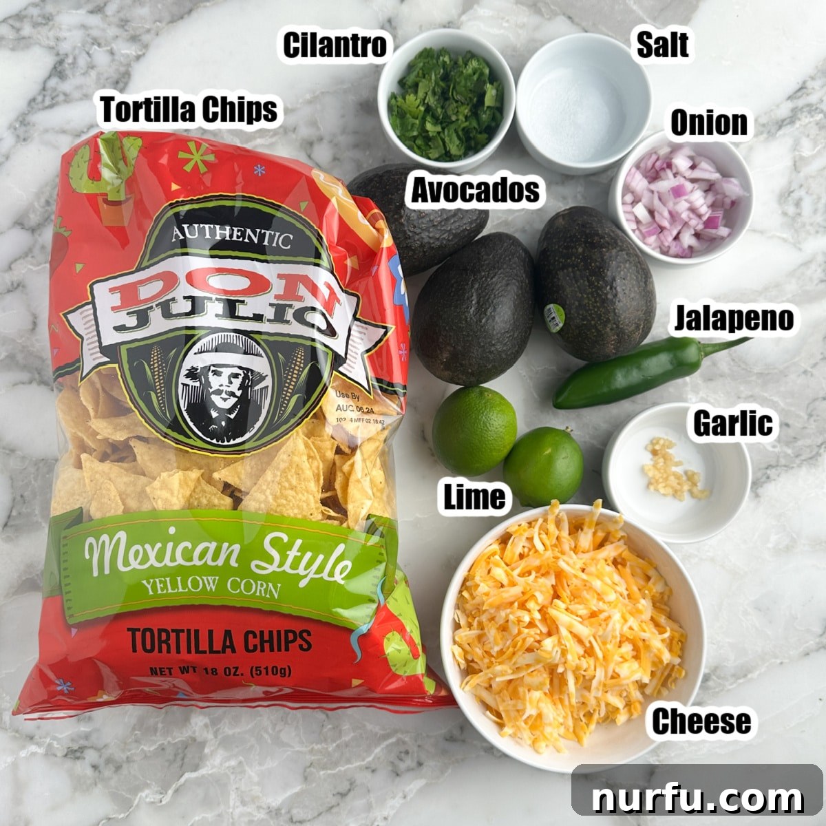 Mastering Guacamole Nachos 3 A vibrant display of fresh ingredients: tortilla chips, ripe avocados, juicy limes, a fiery jalapeño, fragrant cilantro, and finely shredded cheese, ready for guacamole nachos.