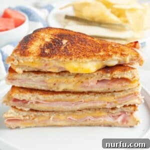 Stack of grilled ham and cheese sandwiches.