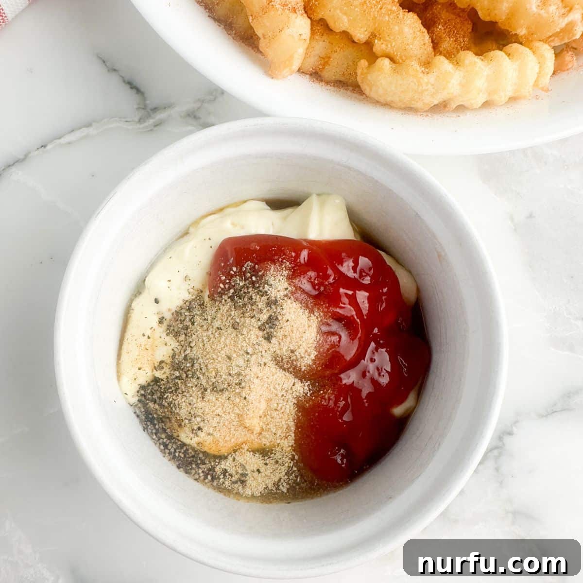 The Ultimate Homemade Zaxby Zax Sauce 4 A bowl containing a mixture of mayonnaise, ketchup, and various dry seasonings, illustrating the initial step of combining ingredients for Zax Sauce.