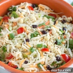 Large bowl of salad with olives, tomatoes and cheese.
