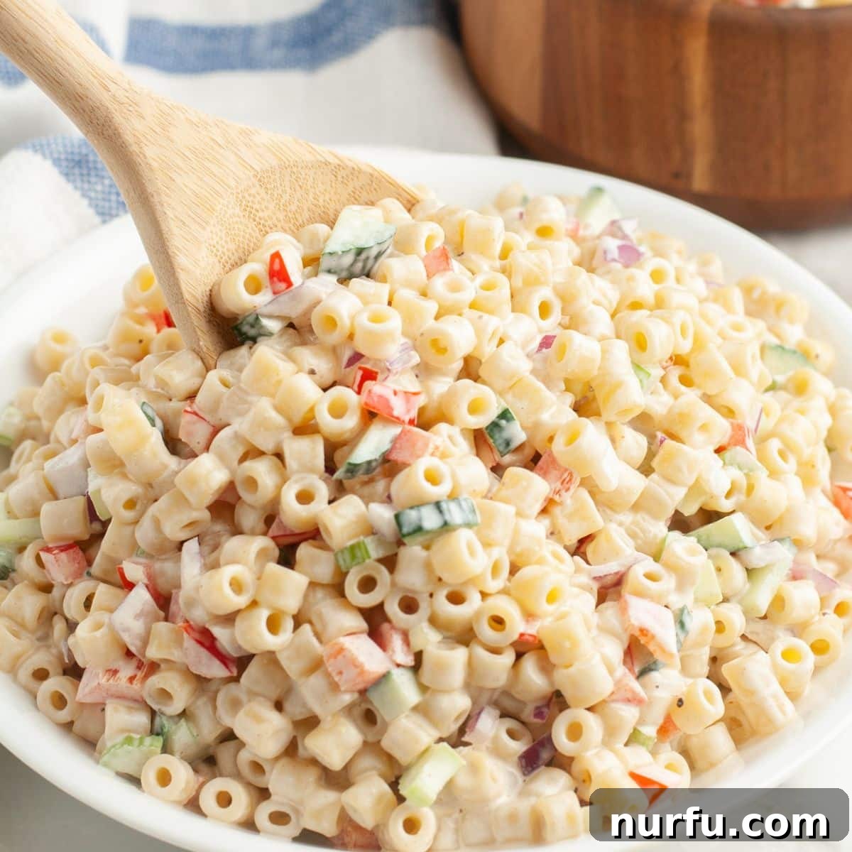 Perfect Sides for Chicken Salad 5 Creamy pasta salad with a wooden spoon.