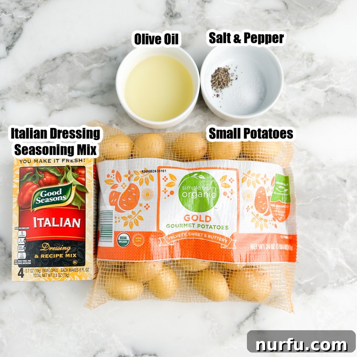 Bag of small gold potatoes, a bowl of olive oil, salt, pepper, and a box of Good Seasons Italian seasoning mix laid out on a rustic surface.