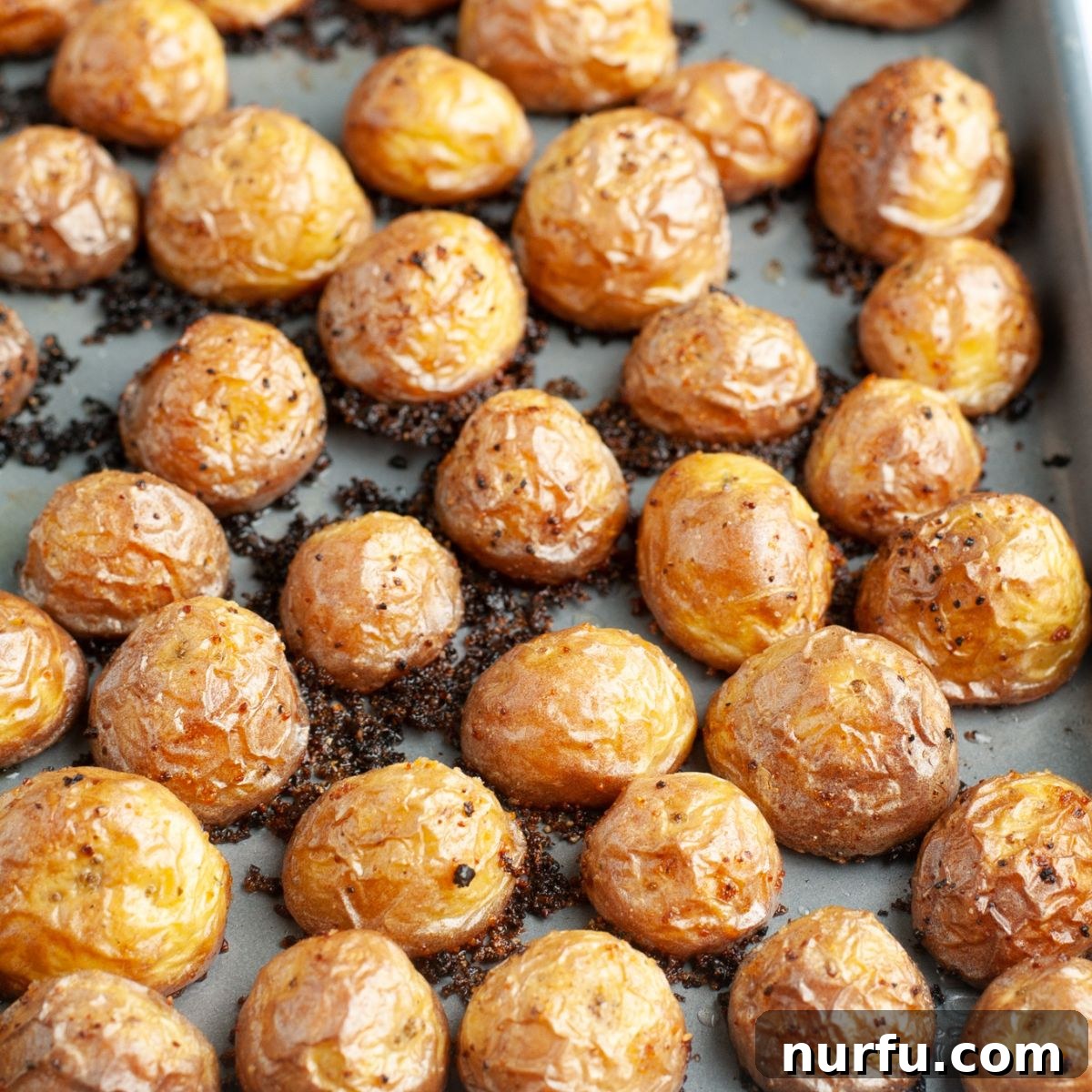 A baking sheet filled with perfectly golden brown and crispy oven roasted potatoes.