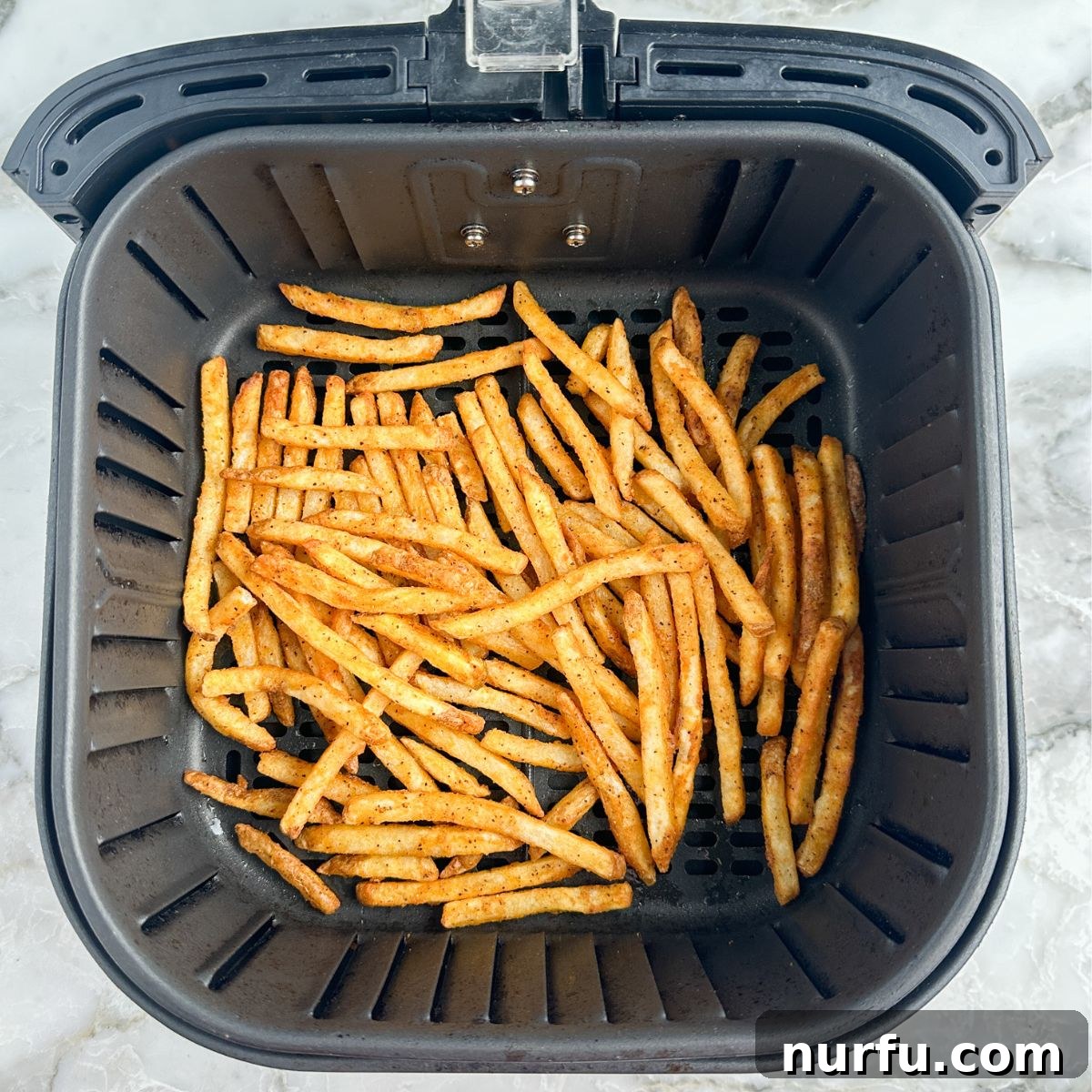 Crispy Checkers Fries in the Air Fryer 5 Cooked french fries in an air fryer basket, perfectly golden brown.
