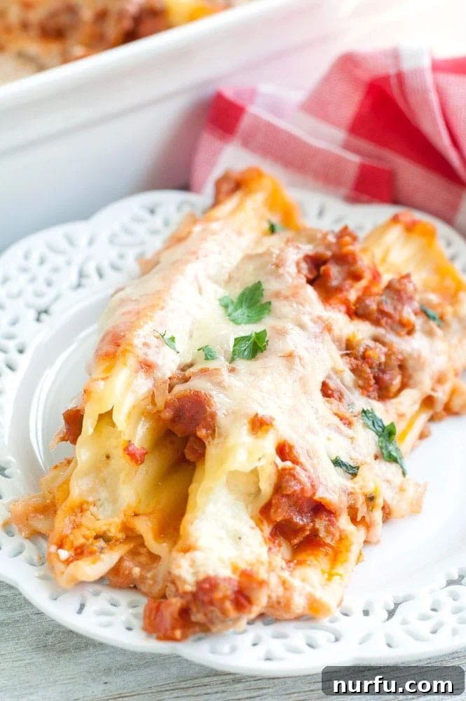 Sausage Manicotti on a Plate A single serving of sausage manicotti on a white plate, garnished with fresh parsley.