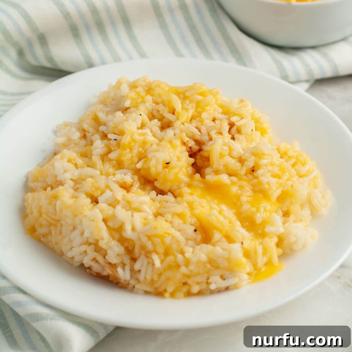 Creamy Cheesy Rice Cooker Perfection 6 A plate of golden, fluffy cheesy rice, ready to be enjoyed.