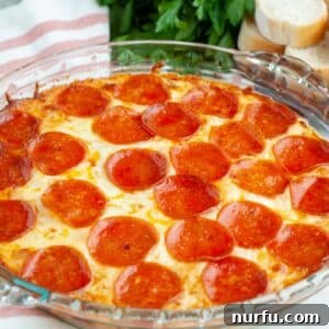 Pizza dip in a baking dish, a cheesy and savory appetizer perfect for any gathering.