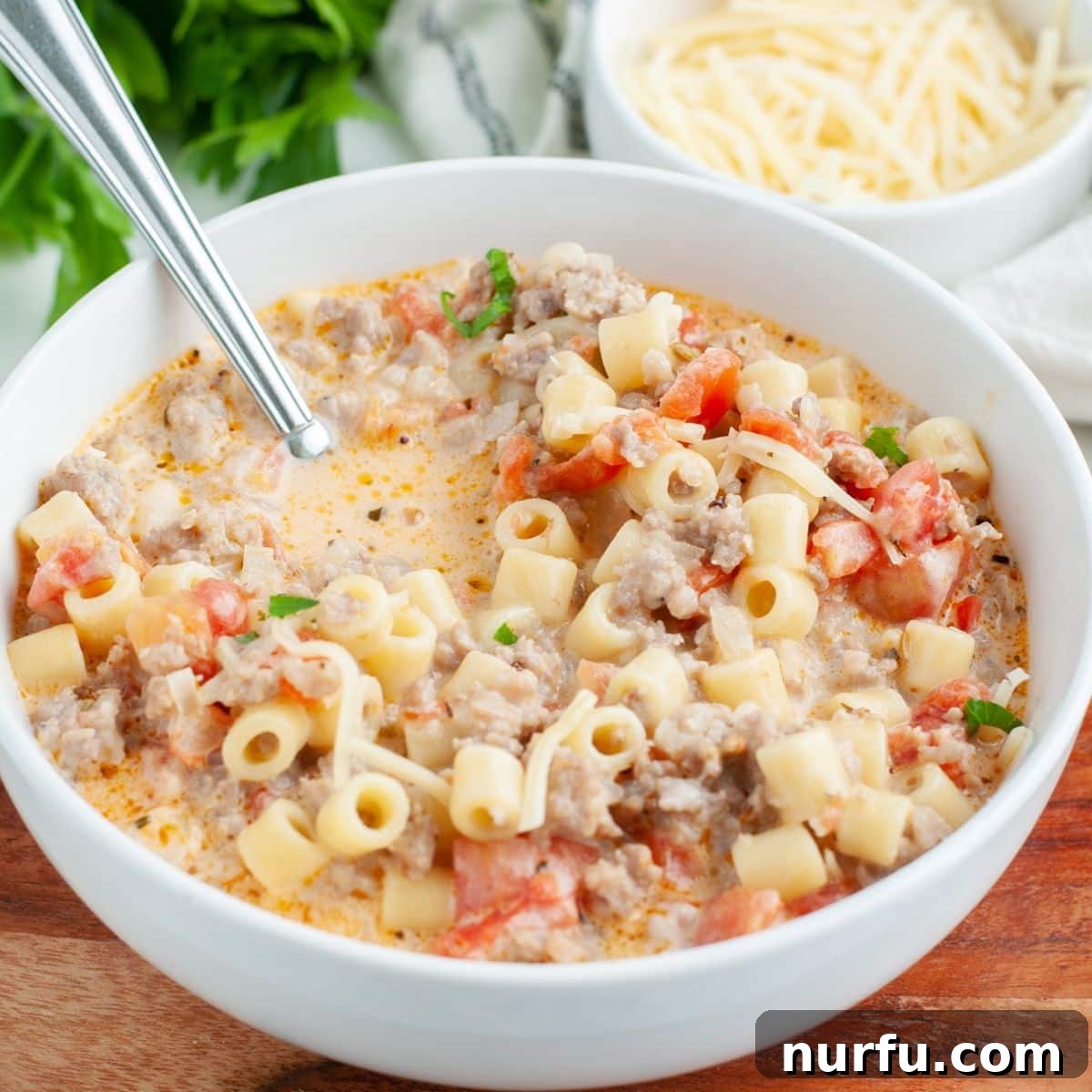 Velvety Italian Sausage and Parmesan Soup 8 A beautifully presented bowl of creamy Italian sausage and pasta soup, garnished with fresh herbs, ready to be enjoyed.