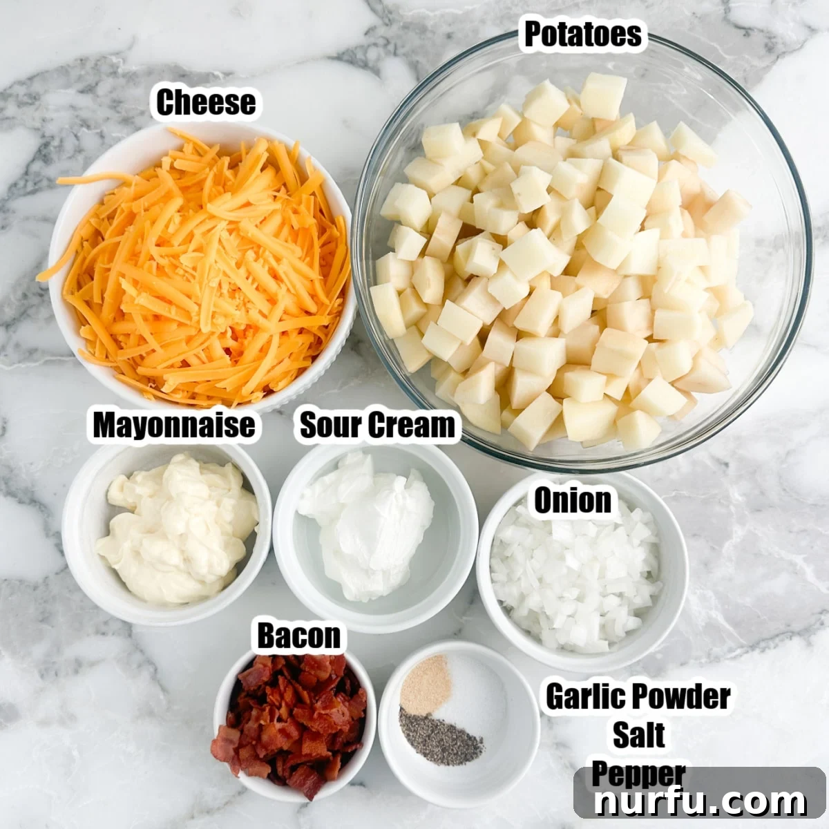 Deep South Mud Pie Potatoes 3 Bowls of fresh ingredients for Mississippi Mud Potatoes: diced potatoes, shredded cheese, crispy bacon, creamy mayonnaise, sour cream, and diced onion.