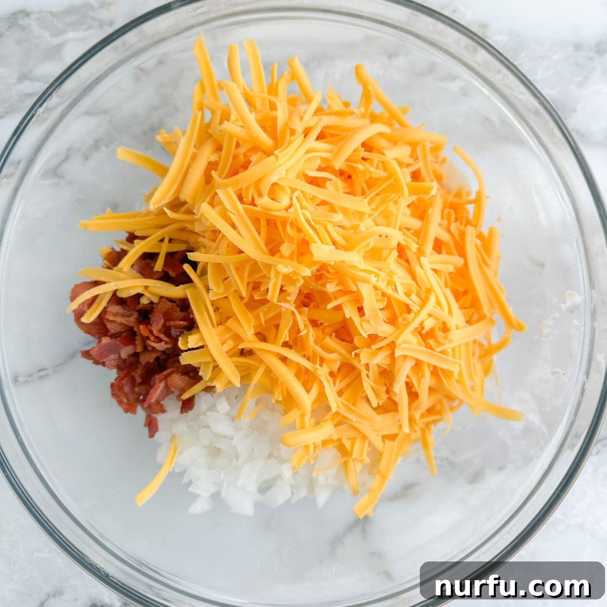 Deep South Mud Pie Potatoes 5 A bowl showcasing the blend of diced onion, crispy bacon bits, and shredded cheese mixed into the creamy sauce.