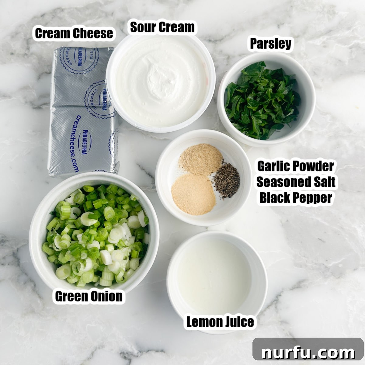 Savory Scallion Dip 3 A curated selection of fresh ingredients laid out: a block of softened cream cheese, a bowl of creamy sour cream, vibrant fresh parsley, finely diced green onions, and various seasonings in small bowls, demonstrating the simplicity of this dip.