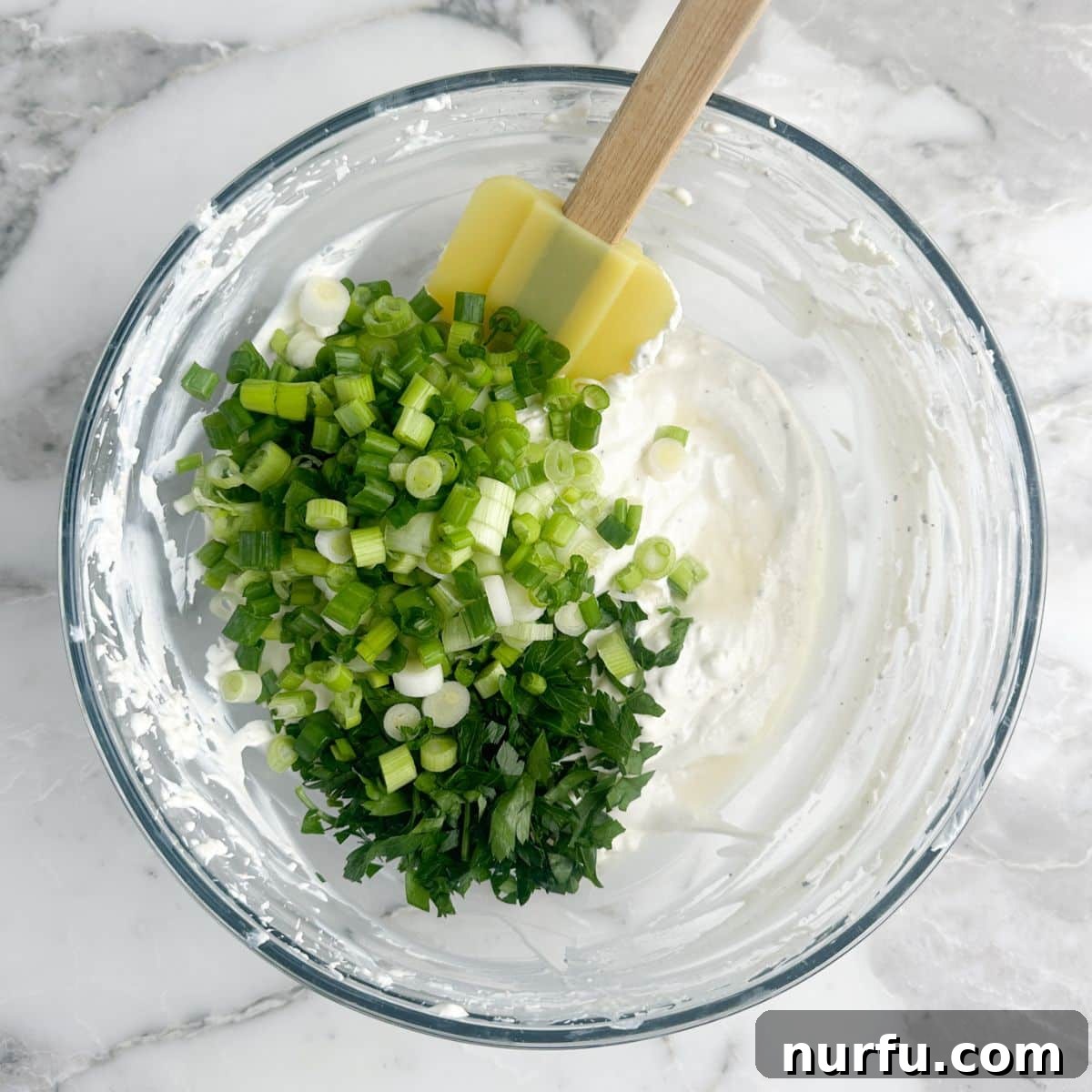 Savory Scallion Dip 5 A bowl of creamy, mixed ingredients, now enhanced with the addition of vibrant diced green onions and fresh chopped parsley, ready for the final chill.